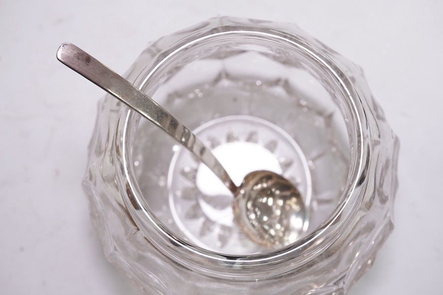 An Edwardian silver mounted hand mirror with Reynold's Angels decoration, William Neale Ltd, Chester, 1902, 26.3cm, together with a later silver mounted cut glass preserve jar and spoon. Condition - poor to fair